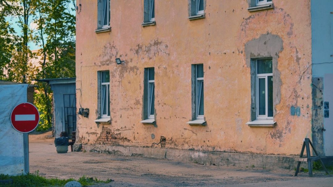 An old building with peeling paint and many windows.